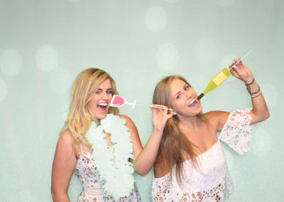 girls in a photo booth with wine props